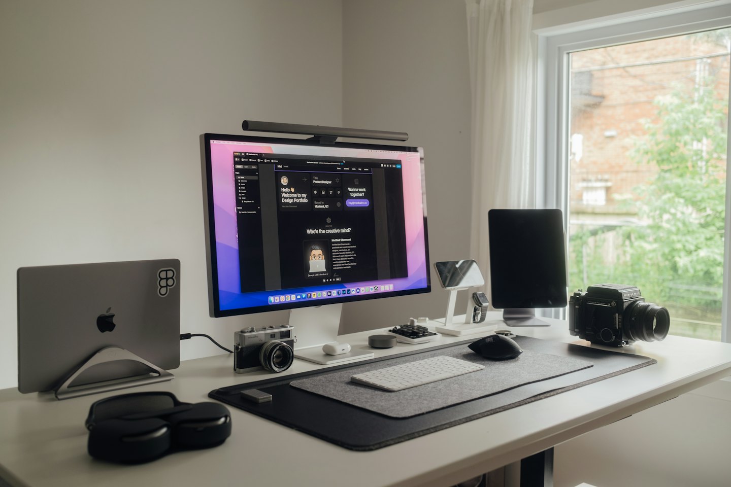 Laptop, Monitor und Tablet auf einem modernen Büroschreibtisch.